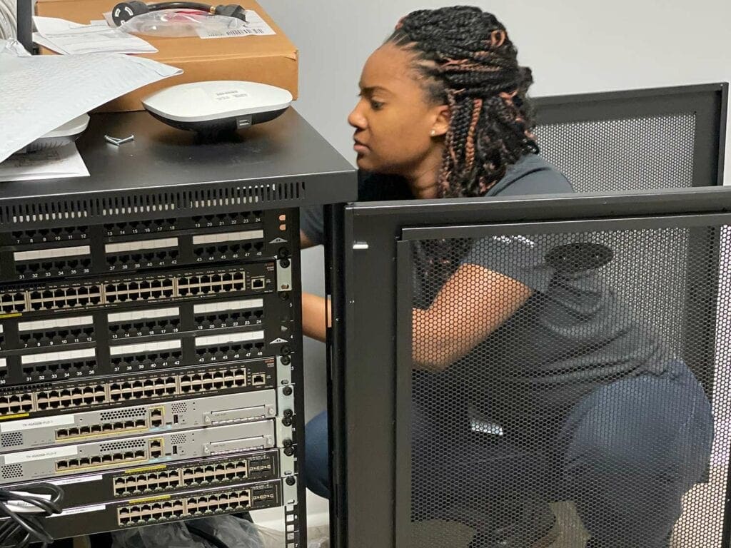 African-American woman installing network hardware